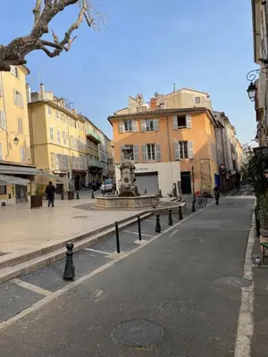 a city street with buildings and a fountain in the middle at Studio plein centre aix en Provence in Aix-en-Provence