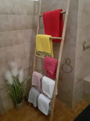 a towel rack with four towels in a bathroom at VILLA PROVENCALE FACE AU LUBERON in Cabrières-dʼAvignon