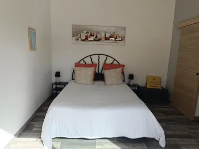 a bedroom with a white bed with red pillows at chambre d hotes la dragonne in Maubec
