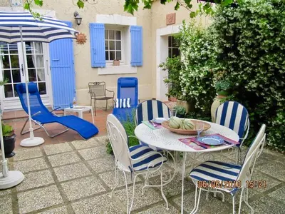 a patio with a table with chairs and an umbrella at le vieux pont in Carpentras