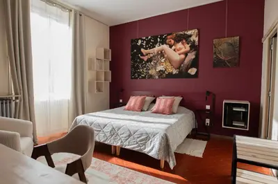 a bedroom with a bed and a painting on the wall at La maison Gerval in Bédoin