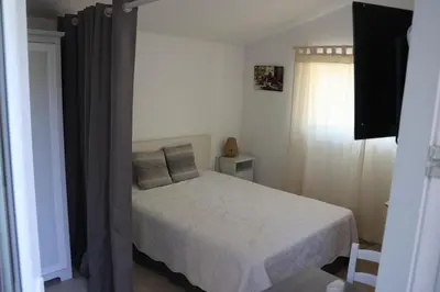 a bedroom with a white bed and a window at Les BRUNS in Saignon