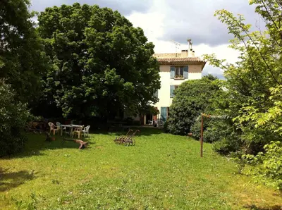 a house in a yard with a table and chairs at SOUS LE TILLEUL CENTENAIRE in La Tour-dʼAigues