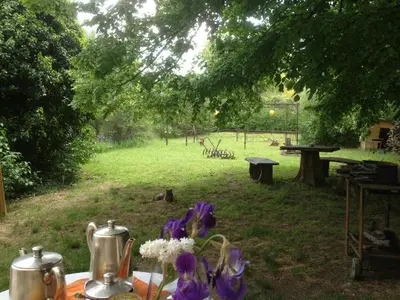 a picnic table with tea pots and flowers in a park at SOUS LE TILLEUL CENTENAIRE in La Tour-dʼAigues