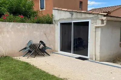 a table and a chair sitting next to a sliding glass door at Loft 21 m² pouvant accueillir 4 personnes in Monteux