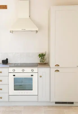 a kitchen with white cabinets and a white oven at La Petite Ruche, 1 bedroom Gite in the Luberon in Apt