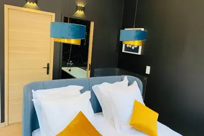 a bedroom with a bed with yellow and white pillows at Suite Le CEZANNE in Aix-en-Provence