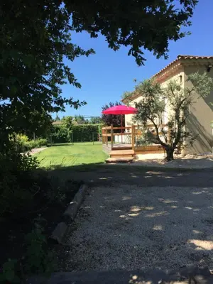 a gazebo with a red umbrella in front of a house at L’ escapade in Mallemort