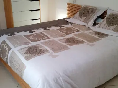 a bed with a white comforter and pillows on it at Maison charmante à Aix-en-Provence avec piscine privée in Aix-en-Provence
