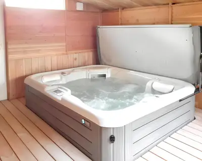 a jacuzzi tub in a room with wooden floors at Maison charmante à Aix-en-Provence avec piscine privée in Aix-en-Provence
