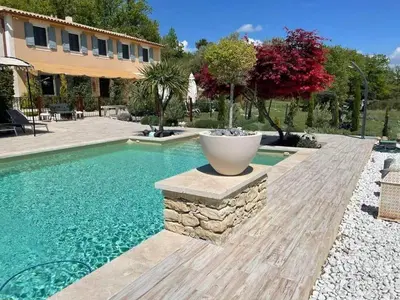 a swimming pool with a planter in a yard at Bastide provençale à Murs, coeur du Lubéron in Murs