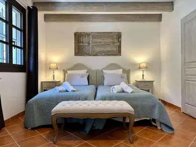 two beds in a room with two tables and two lamps at Bastide provençale à Murs, coeur du Lubéron in Murs