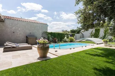a backyard with a swimming pool and a vase of flowers at Le Parc in Carpentras