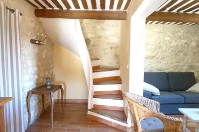 a living room with a staircase with a blue couch at Le Tilleul in Lacoste