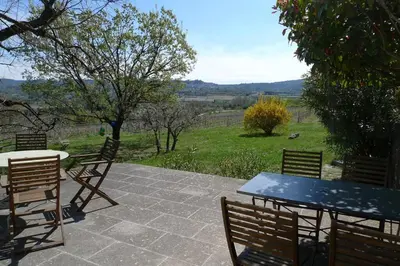 a table and chairs on a patio with a view of a field at Le Tilleul in Lacoste