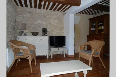 a living room with two chairs and a tv at Le Tilleul in Lacoste