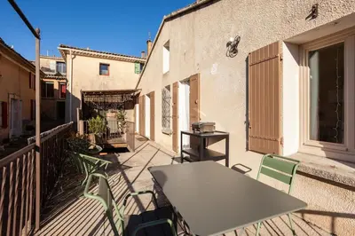 a table and chairs on the balcony of a building at La maison de Gaston au cœur du Luberon in Villars