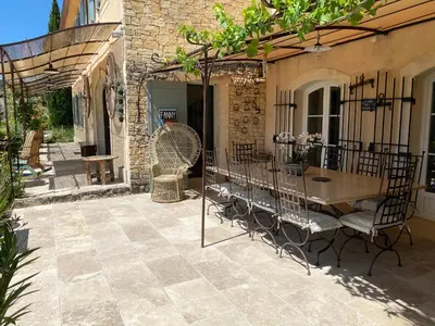 a patio with a table and chairs and a building at Location bastide provencale Luberon in Murs