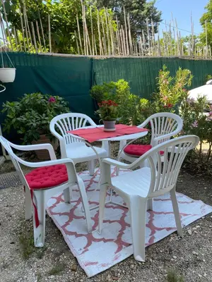 a table and four chairs with a red table at Côté Court in LʼIsle-sur-la-Sorgue