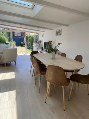 a dining room with a wooden table and chairs at Côté Court in LʼIsle-sur-la-Sorgue