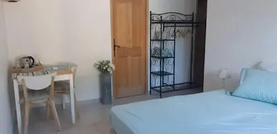 a bedroom with a bed and a table and a desk at Maison d'Hôtes & Spa La Chêneraie-Provence Ventoux in Saint-Didier