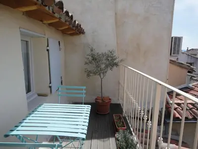 a balcony with a blue bench and a potted tree at LOlivier sur le Toit in LʼIsle-sur-la-Sorgue