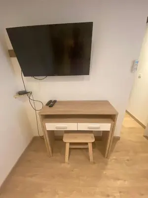 a wooden desk with a television on a wall at A l’ombre du géant de Provence in Mormoiron