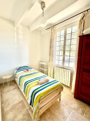 a bedroom with a bed and a large window at Mas d'Olea - heated swimming pool - airco - 14pers in Lauris