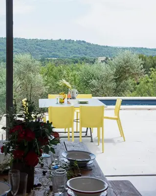 a table and chairs on a patio with a view at l'Atelier des Milles Roches in Gordes