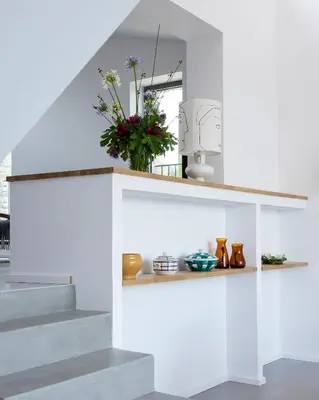 a white staircase with a shelf with flowers on it at l'Atelier des Milles Roches in Gordes