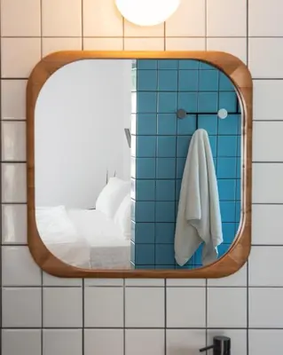 a mirror on a tiled wall in a bathroom at l'Atelier des Milles Roches in Gordes