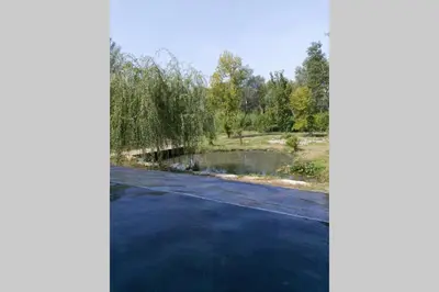 a road with a pond in the middle at Un petit coin de Bali avec SPA et piscine privés in Carpentras