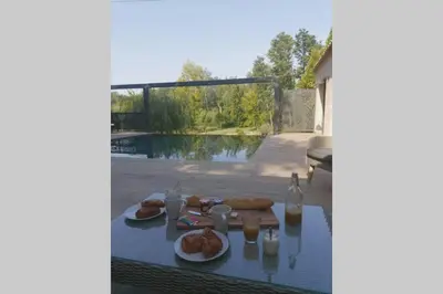 a table with food and drinks on top of a patio at Un petit coin de Bali avec SPA et piscine privés in Carpentras