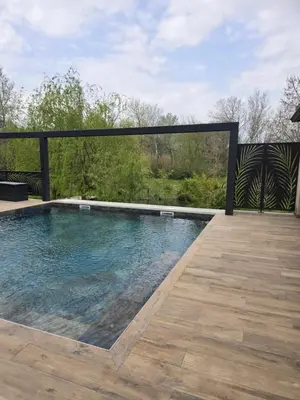 a swimming pool on a patio with a wooden deck at Un petit coin de Bali avec SPA et piscine privés in Carpentras