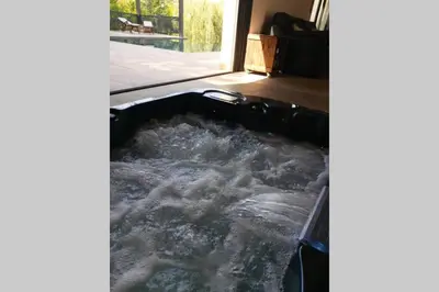a bathtub filled with water in a room at Un petit coin de Bali avec SPA et piscine privés in Carpentras