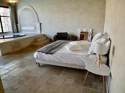 a bedroom with a large bed and a bath tub at Le Pool House - Private Jacuzzi - Mas des Sous Bois in Ventabren