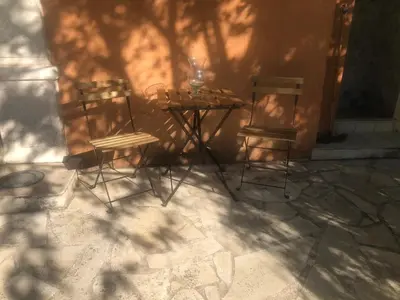 two chairs and a table in front of a wall at Le Pool House - Private Jacuzzi - Mas des Sous Bois in Ventabren