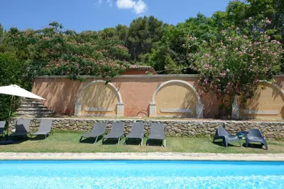 a group of chairs sitting next to a swimming pool at Le Pool House - Private Jacuzzi - Mas des Sous Bois in Ventabren