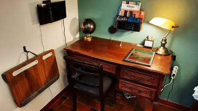 a desk with a lamp and a chair in a room at La Maison du Chemin des Prairies in Morières-lès-Avignon