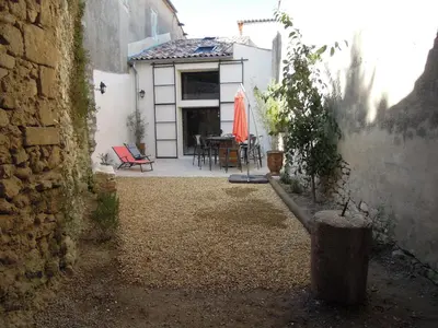 a house with a patio with a table and an umbrella at La Bourgade in Céreste