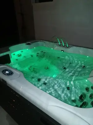 a bath tub with green water in it at L'atelier de Guytou et Spa in Cheval-Blanc