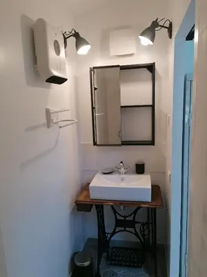 a bathroom with a sink and a mirror at L'atelier de Guytou et Spa in Cheval-Blanc