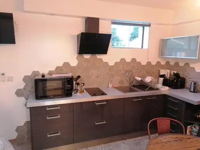 a kitchen with a microwave and a sink and a counter at L'atelier de Guytou et Spa in Cheval-Blanc