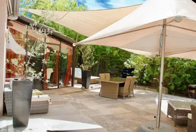 a patio with an umbrella and a table and chairs at LASUITE Domaine Bertuli, heated Pool, Aircon in Oppède