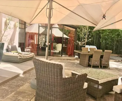 a patio with a table and chairs and an umbrella at LASUITE Domaine Bertuli, heated Pool, Aircon in Oppède