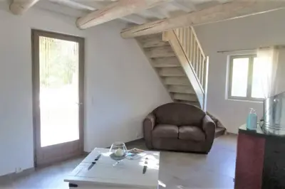 a living room with a chair and a table at Mas de la Chêneraie Blanche, Maison de vacances avec piscine en Luberon in Roussillon