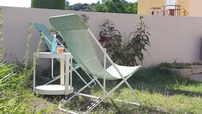 a green and white chair sitting in the grass at Provence Luberon Goult Gite Mafasuza in Goult