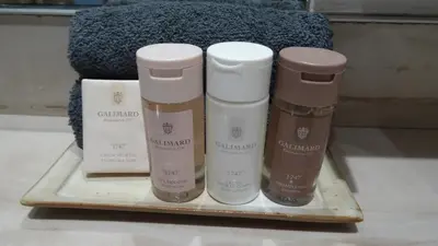 three bottles of moisturizers sitting on a tray at Les Cerisiers maison bertuli climatisé, Piscine chauffée, lit King size, classé 5 étoiles in Oppède
