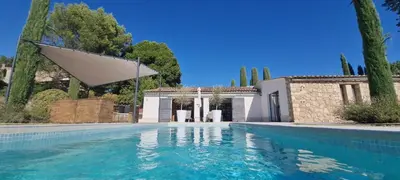 a swimming pool in front of a house at Les Cerisiers maison bertuli climatisé, Piscine chauffée, lit King size, classé 5 étoiles in Oppède