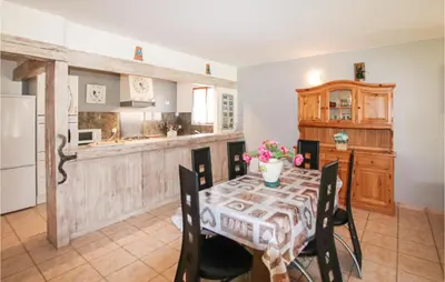 a kitchen with a table with chairs and a counter at Cozy Home In Carpentras in Carpentras